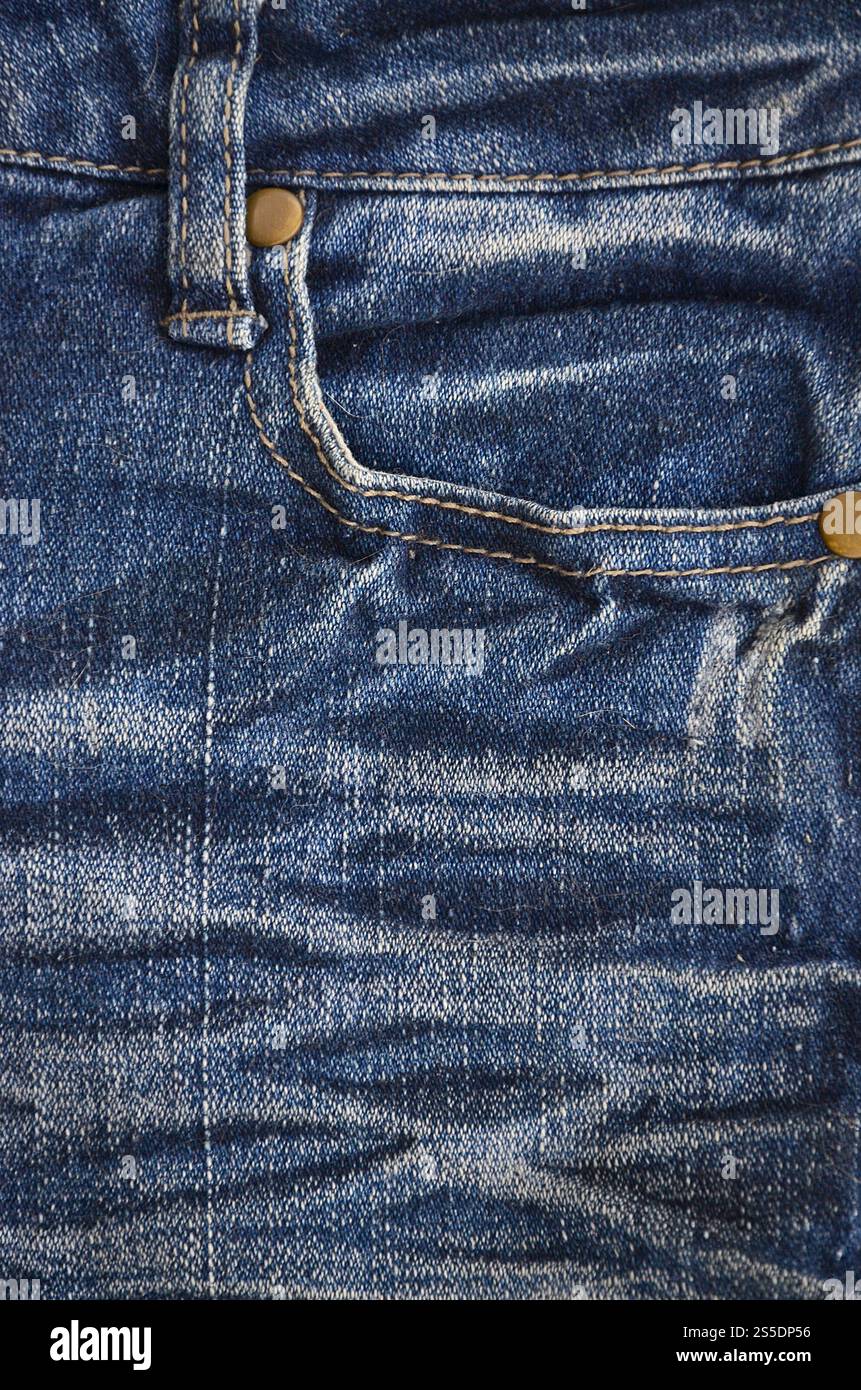 Fragment de texture denim en teintes classiques avec des coutures de tissu fin et une grande poche. L'image de fond sur la production de denim rigide Banque D'Images