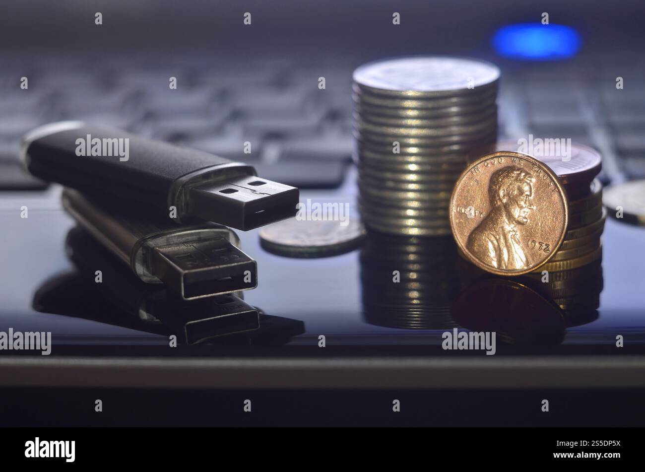 Cartes flash USB couchées sur le boîtier noir de l'ordinateur portable devant son clavier. Le concept de gagner sur Internet, monétisation en ligne et paiement de Banque D'Images