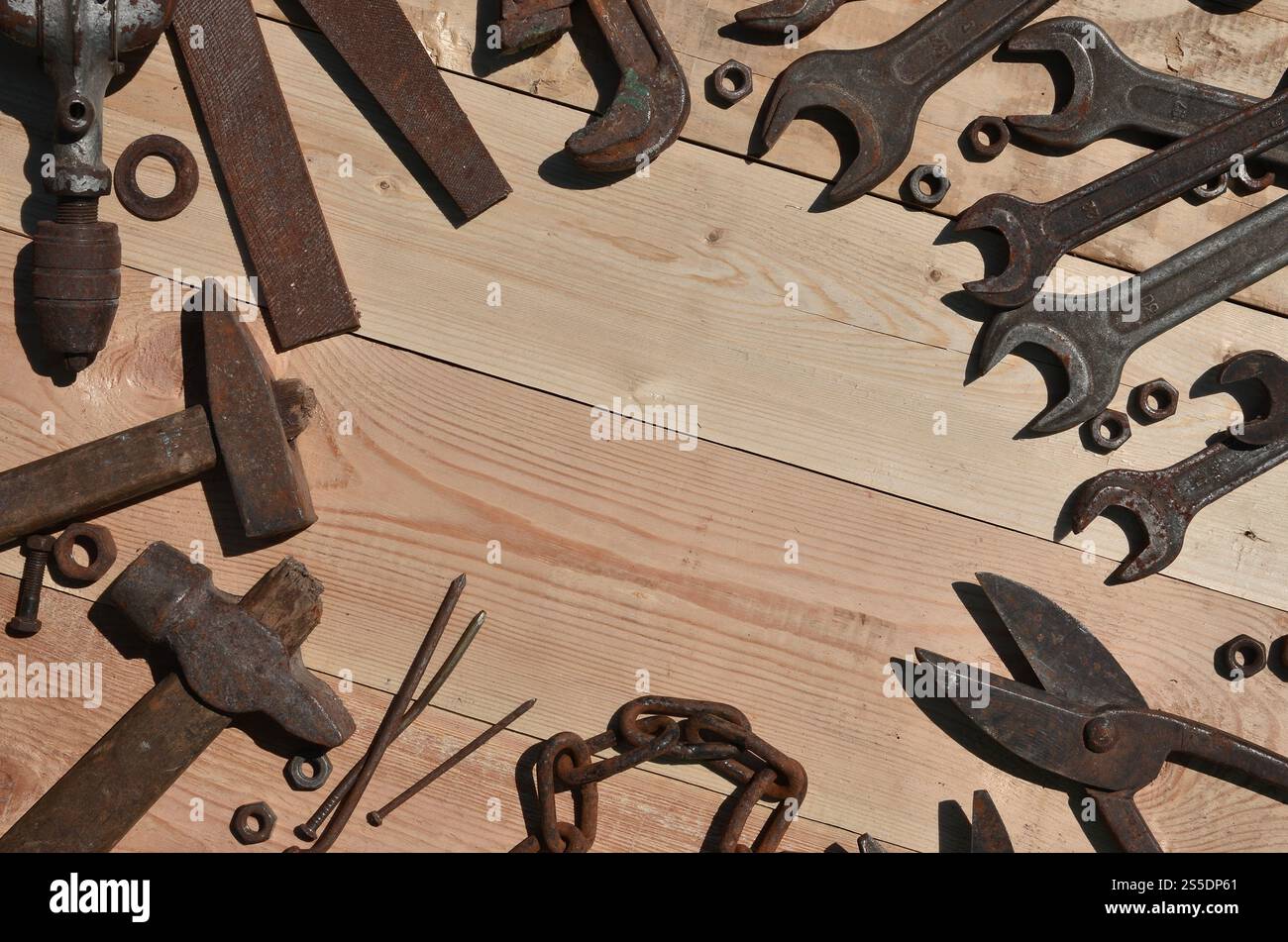 Un ensemble d'outils vieux et rouillés pour bricoleur. Beaucoup d'outils ménagers obsolètes en métal rouillé reposent sur une table en bois dans l'atelier. Le concept de Banque D'Images