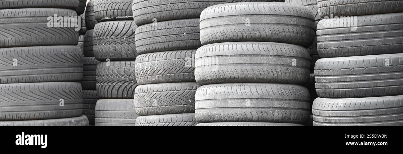 Vieux pneus usagés empilés avec des piles élevées dans le garage secondaire de magasin de pièces de voiture de près. Vieux pneus usagés empilés avec des piles élevées dans des pièces de voiture secondaires Banque D'Images