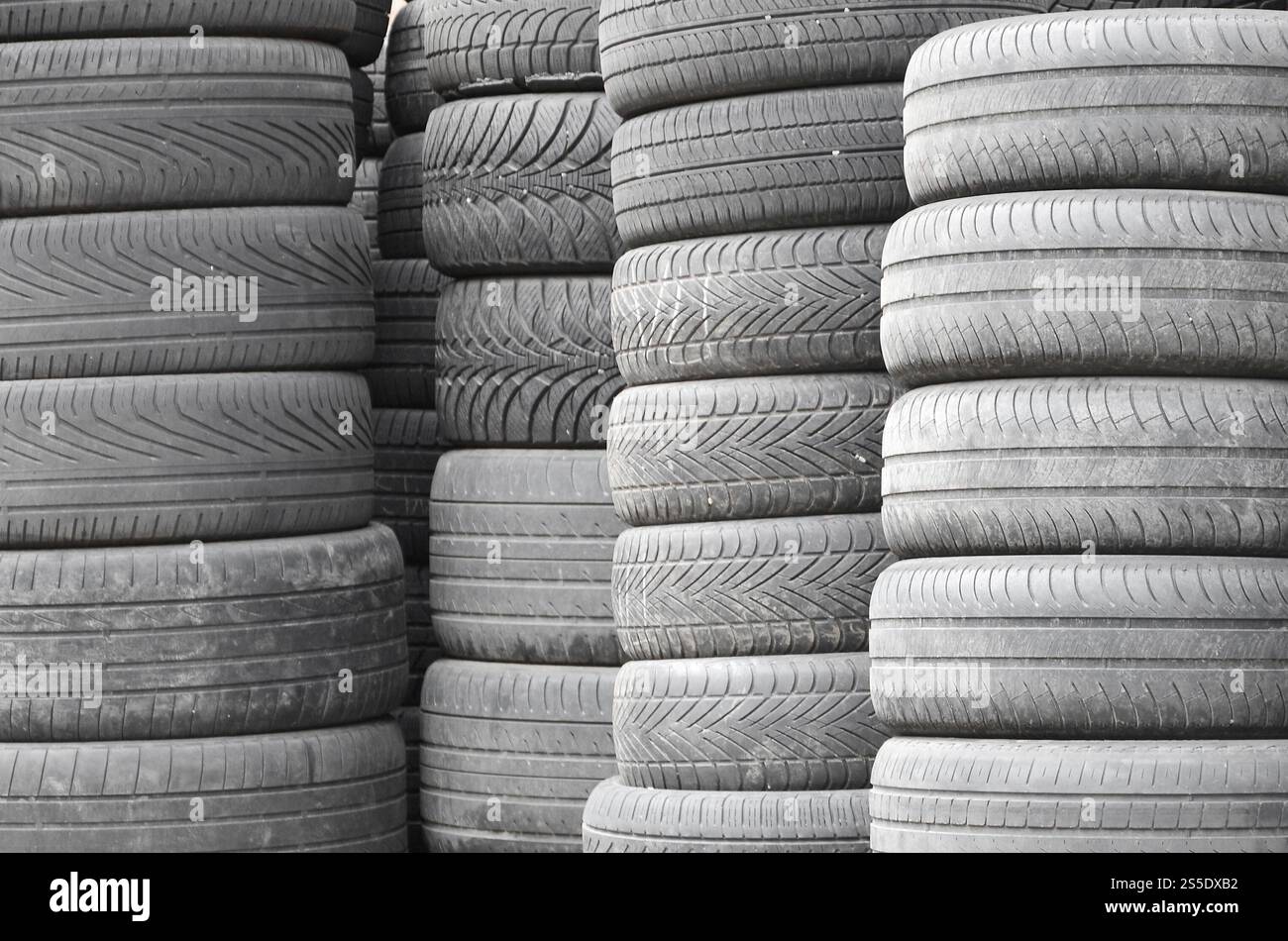 Vieux pneus usagés empilés avec des piles élevées dans le garage secondaire de magasin de pièces de voiture de près. Vieux pneus usagés empilés avec des piles élevées dans des pièces de voiture secondaires Banque D'Images