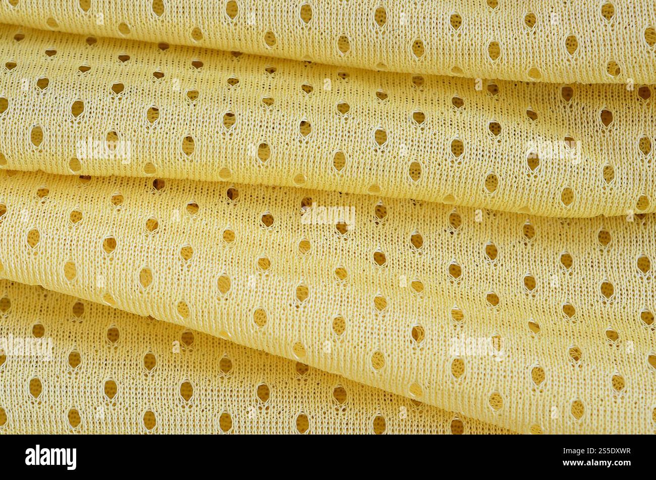Fond de modèle textile de tissu de tissu de sport de maille jaune. Couleur jaune maillot de football vêtements tissu texture vêtements de sport. Poreux respirant Banque D'Images