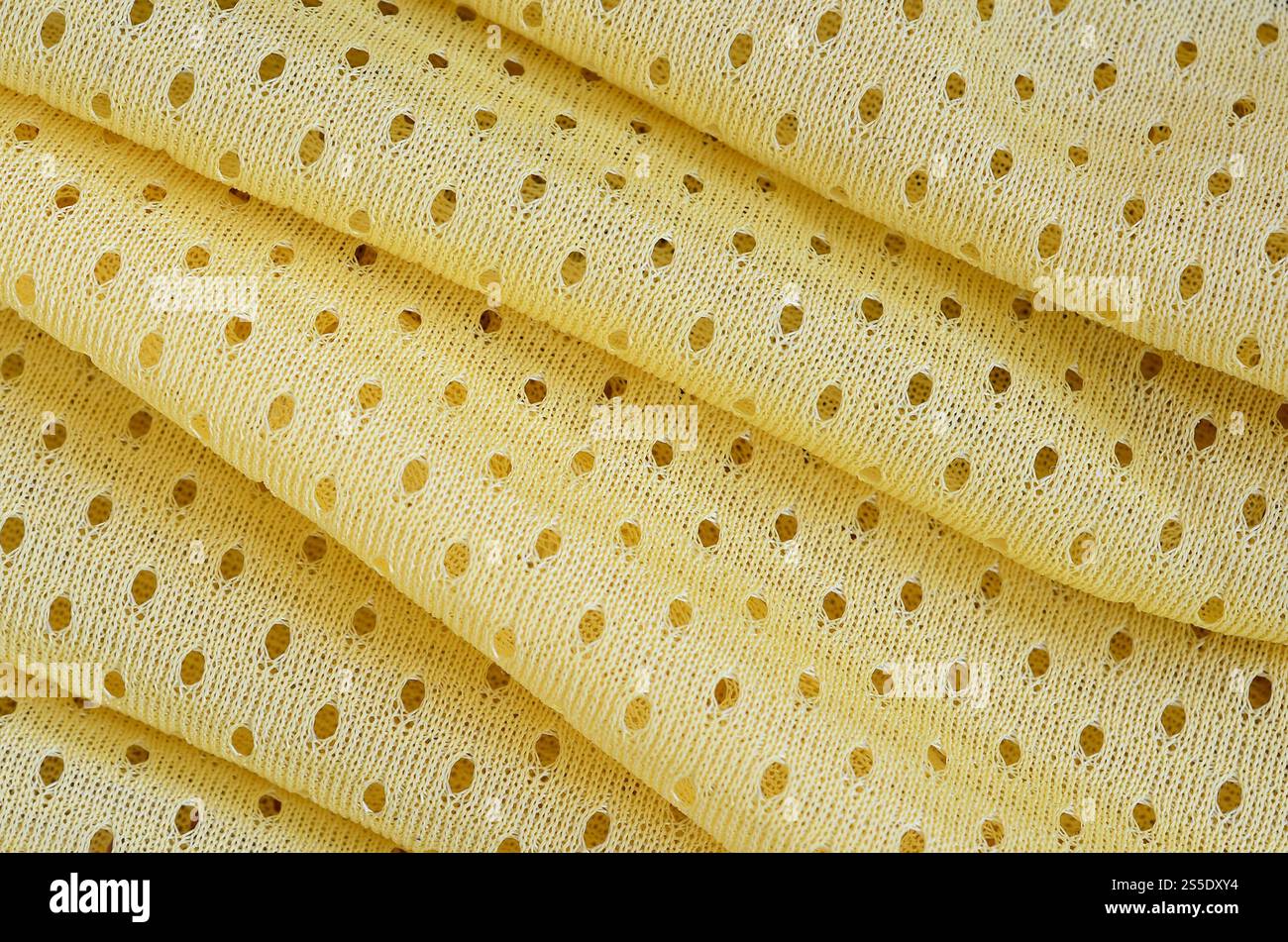 Fond de modèle textile de tissu de tissu de sport de maille jaune. Couleur jaune maillot de football vêtements tissu texture vêtements de sport. Poreux respirant Banque D'Images
