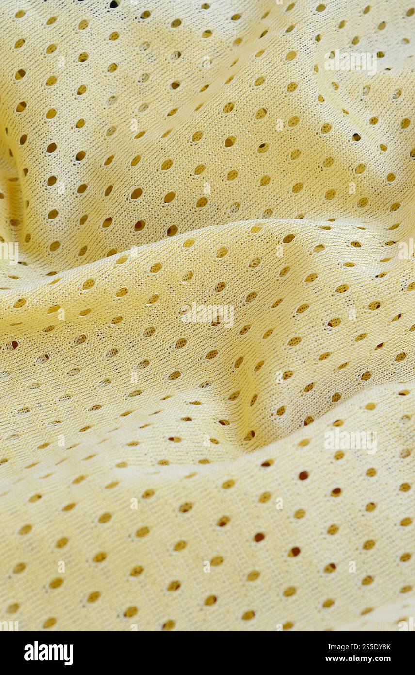 Fond de modèle textile de tissu de tissu de sport de maille jaune. Couleur jaune maillot de football vêtements tissu texture vêtements de sport. Poreux respirant Banque D'Images