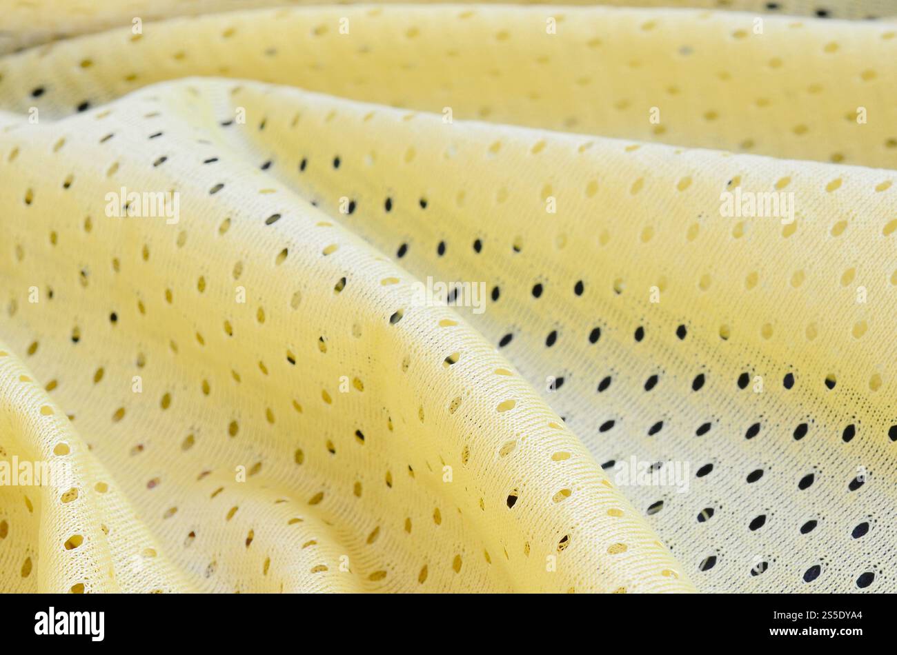 Fond de modèle textile de tissu de tissu de sport de maille jaune. Couleur jaune maillot de football vêtements tissu texture vêtements de sport. Poreux respirant Banque D'Images