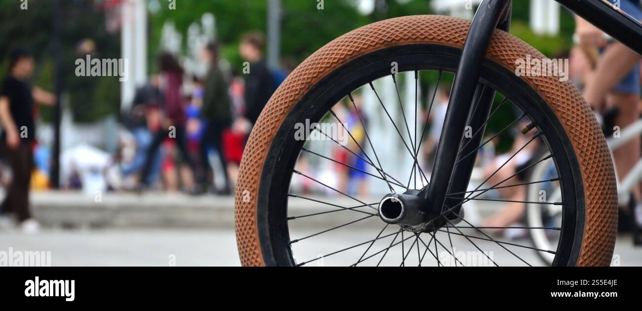 Une roue de vélo BMX dans le contexte d'une rue avec des coureurs cyclistes brouillée. Extreme Sports Concept Banque D'Images Une roue de vélo BMX dans le contexte d'une rue avec des coureurs cyclistes brouillée. Extreme Sports Concept Banque D'Images