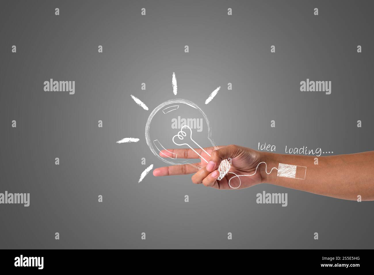 Une main qui tient deux doigts et tient une ampoule avec le chargement des idées, dessiner le concept. Banque D'Images