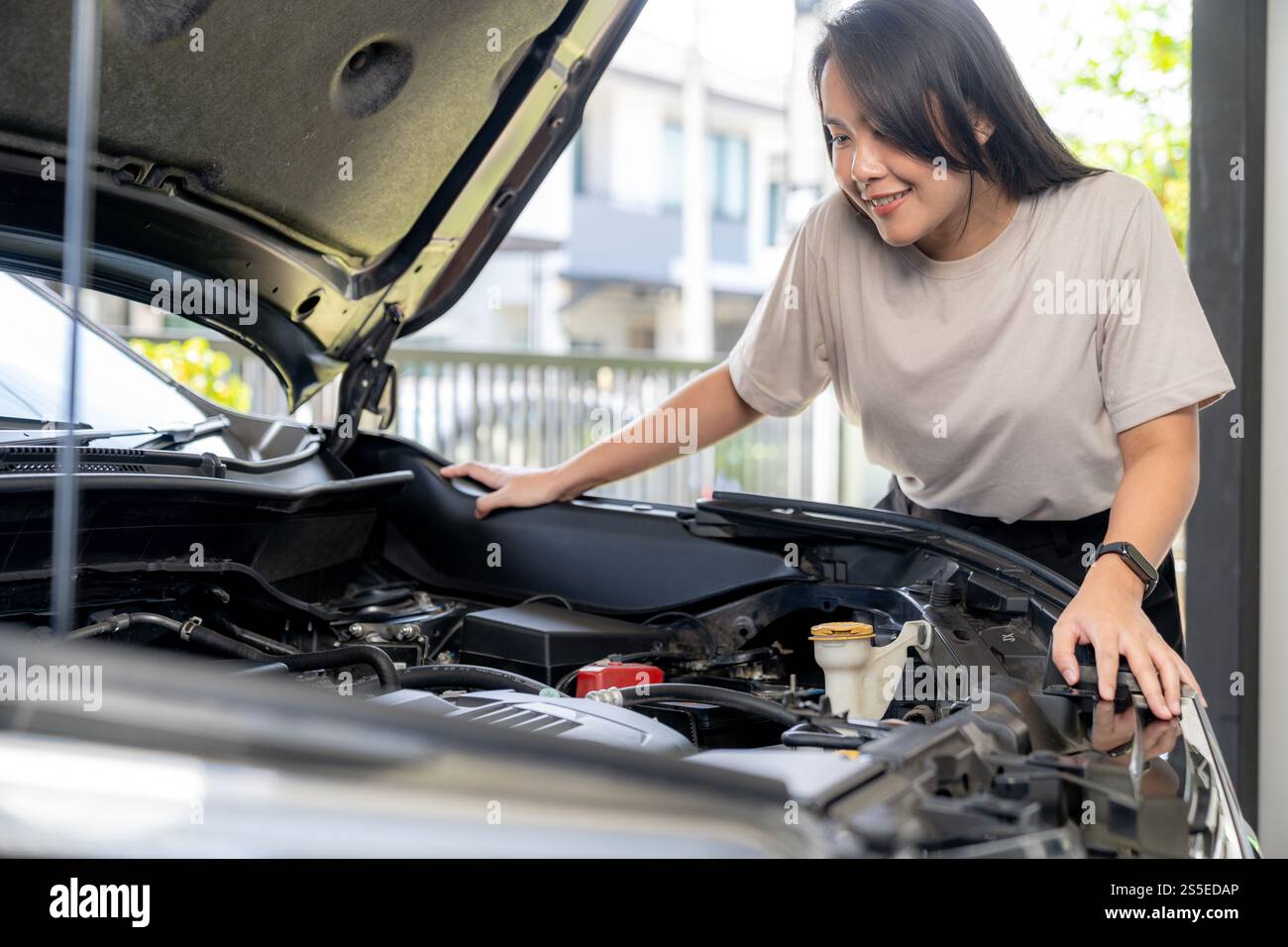 Une femme vérifie sa voiture avant de voyager Banque D'Images Une femme vérifie sa voiture avant de voyager Banque D'Images