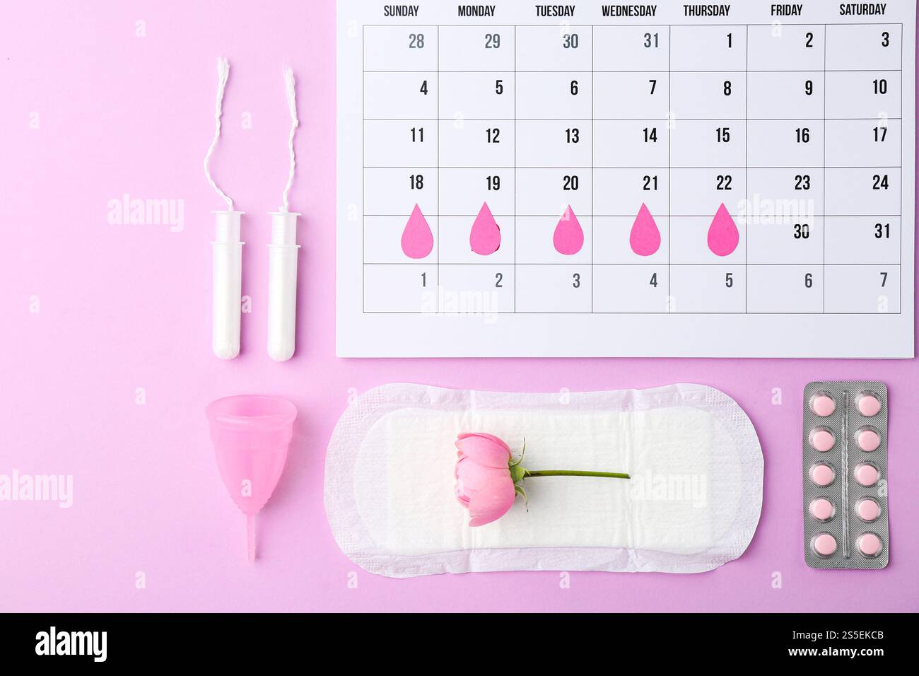 Composition de pose plate avec calendrier et produits menstruels sur fond violet Banque D'Images