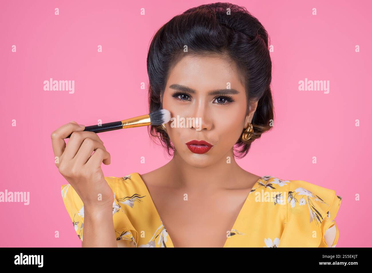 Portrait d'une femme avec un spectacle professionnel de pinceau à maquillage Banque D'Images