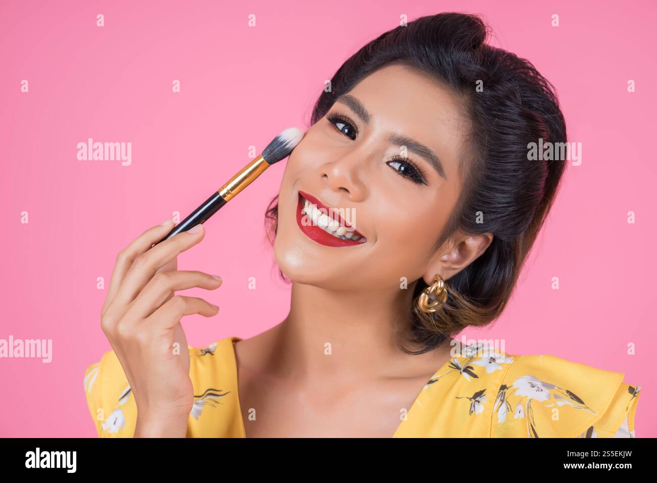 Portrait d'une femme avec un spectacle professionnel de pinceau à maquillage Banque D'Images
