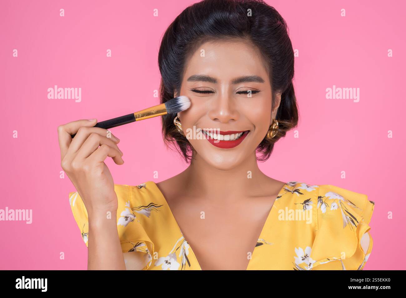 Portrait d'une femme avec un spectacle professionnel de pinceau à maquillage Banque D'Images