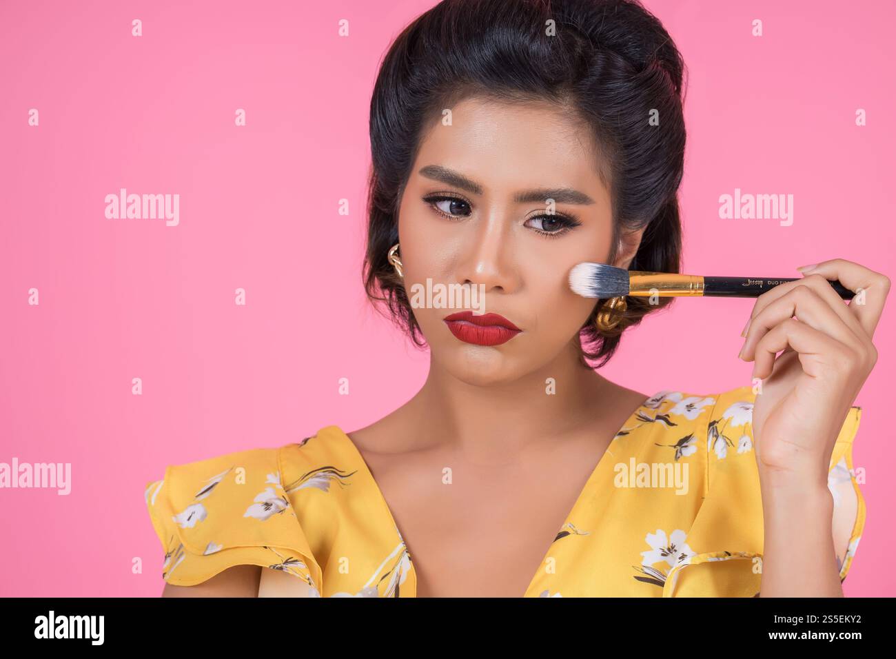 Portrait d'une femme avec un spectacle professionnel de pinceau à maquillage Banque D'Images