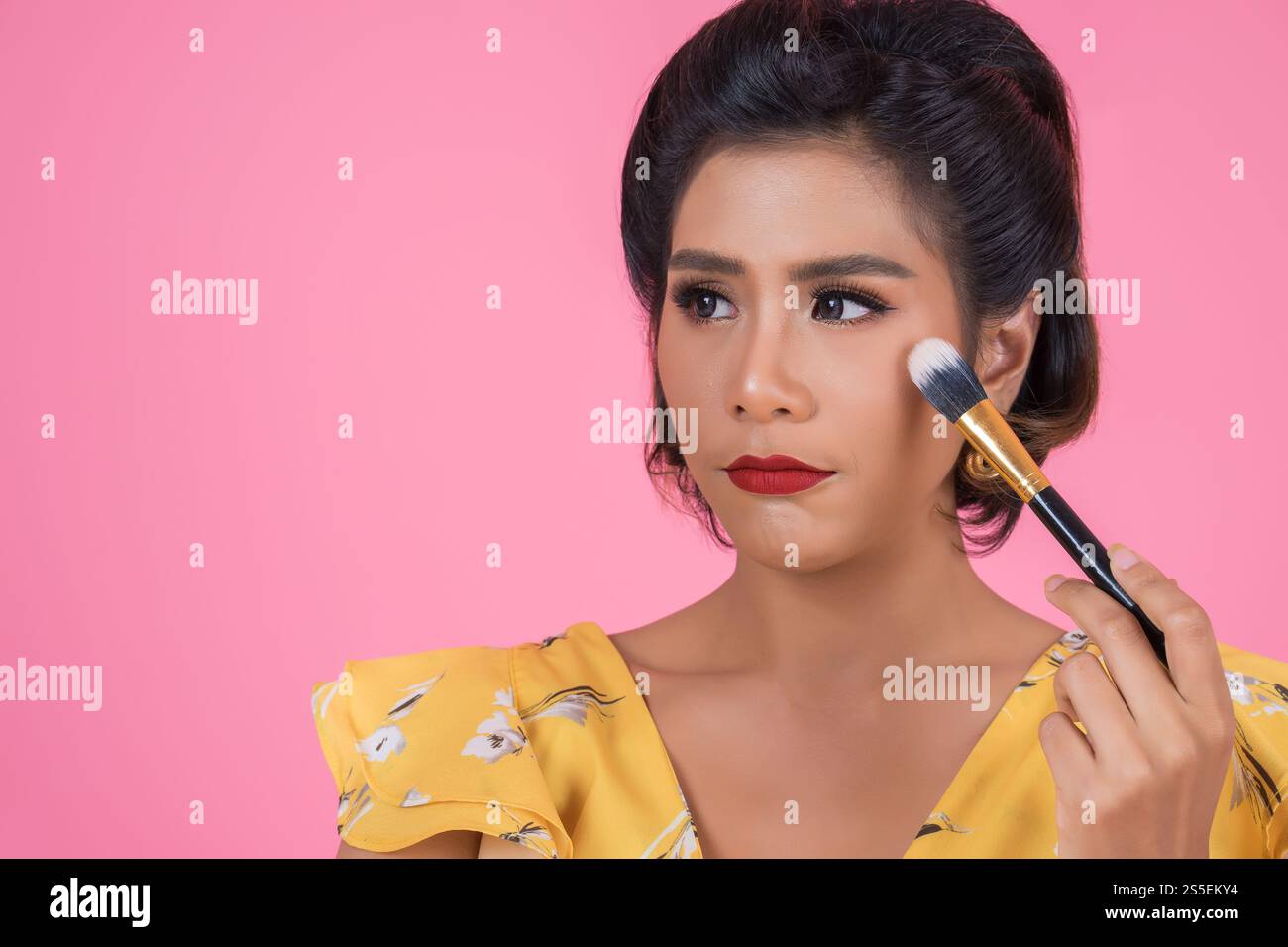 Portrait d'une femme avec un spectacle professionnel de pinceau à maquillage Banque D'Images