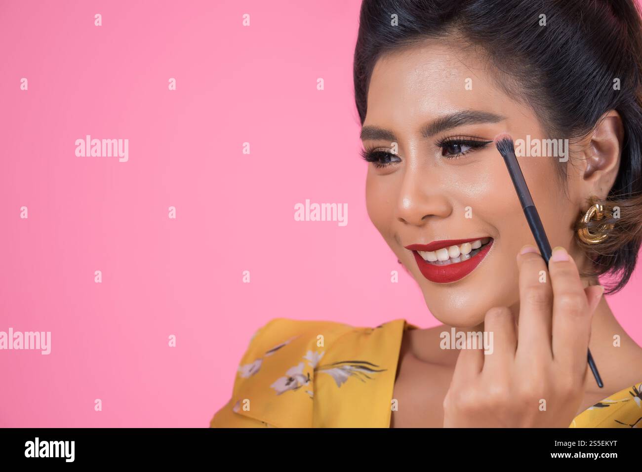 Portrait d'une femme avec un spectacle professionnel de pinceau à maquillage Banque D'Images