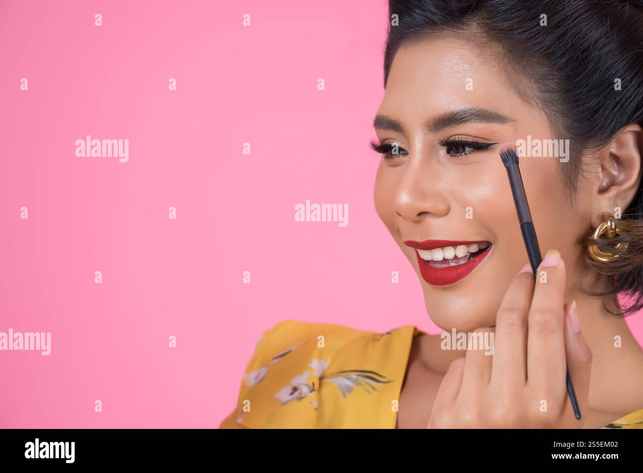 Portrait d'une femme avec un spectacle professionnel de pinceau à maquillage Banque D'Images