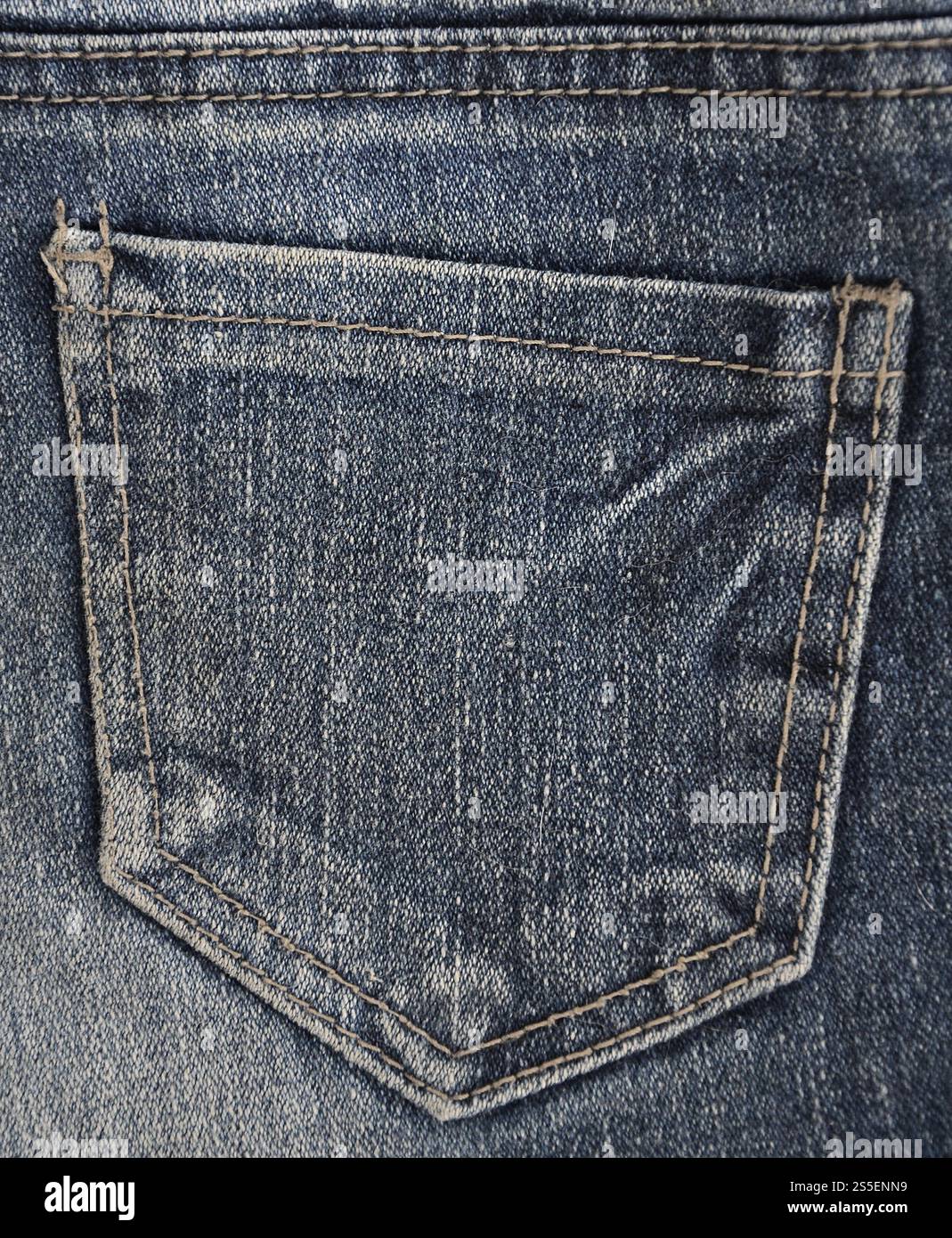 Fragment de texture denim en teintes classiques avec des coutures de tissu fin et une grande poche. L'image de fond sur la production de denim rigide Banque D'Images