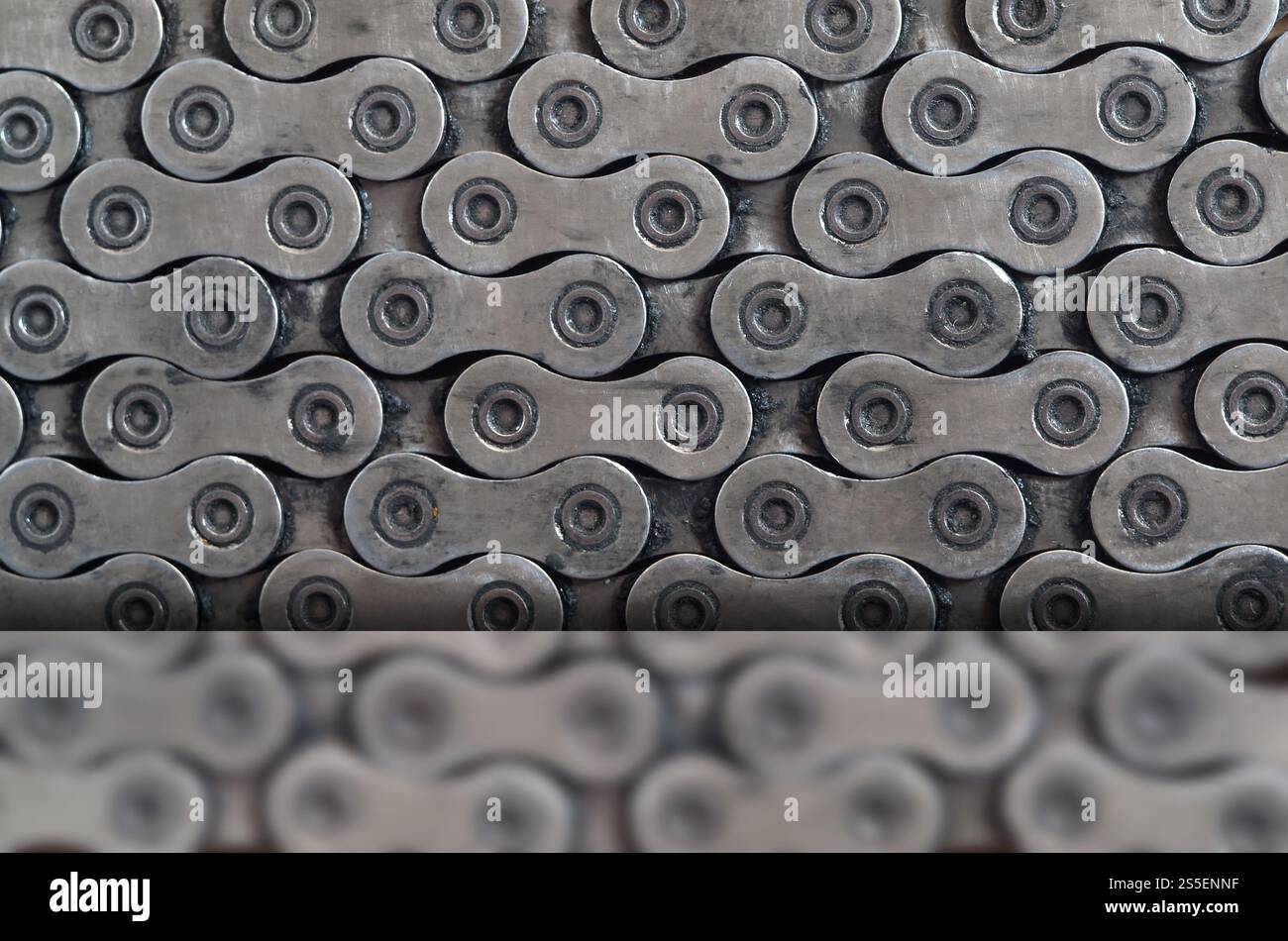 Chaîne sale et huileuse d'un vélo de montagne couché sur une table en bois dans un magasin de vélos. Un des principaux éléments de la transmission du couple sur les vélos Banque D'Images