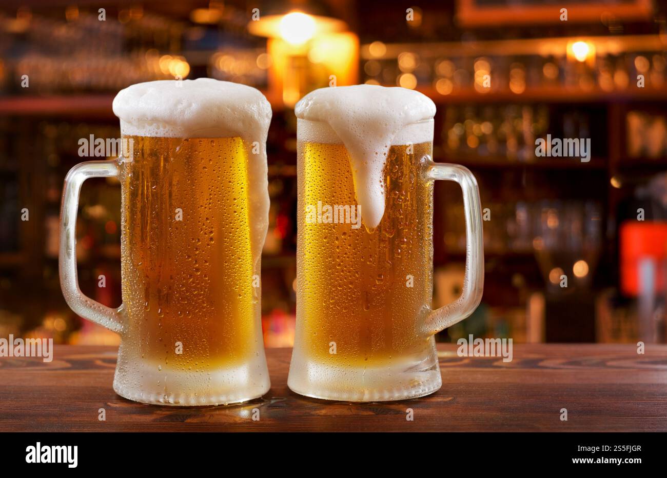 Tasses froides de bière dans un bar sur le comptoir en bois Banque D'Images