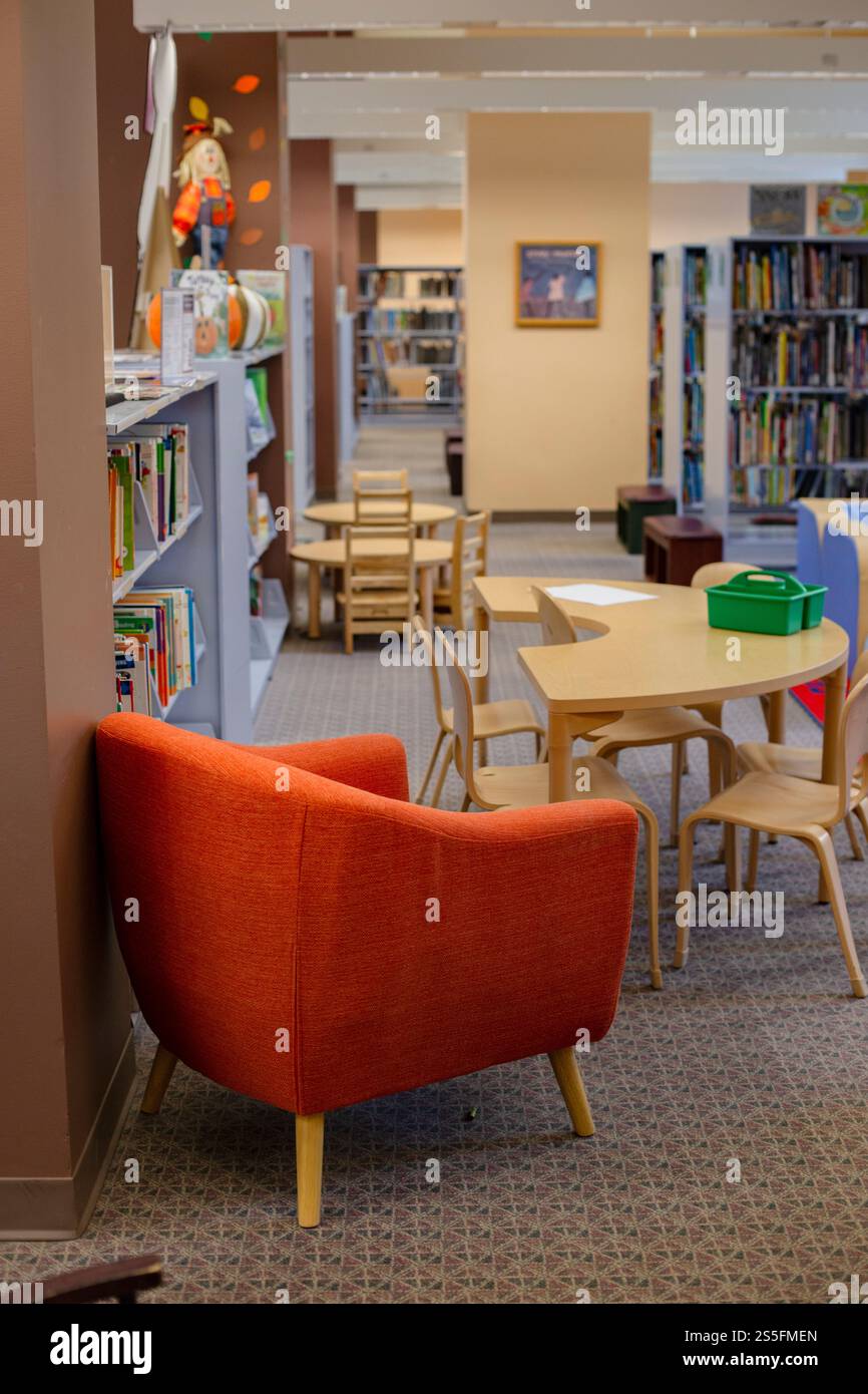 Chaises entourant une table dans une bibliothèque avec des étagères et des jouets pour enfants et des livres en arrière-plan. Cleveland, Ohio, États-Unis Banque D'Images