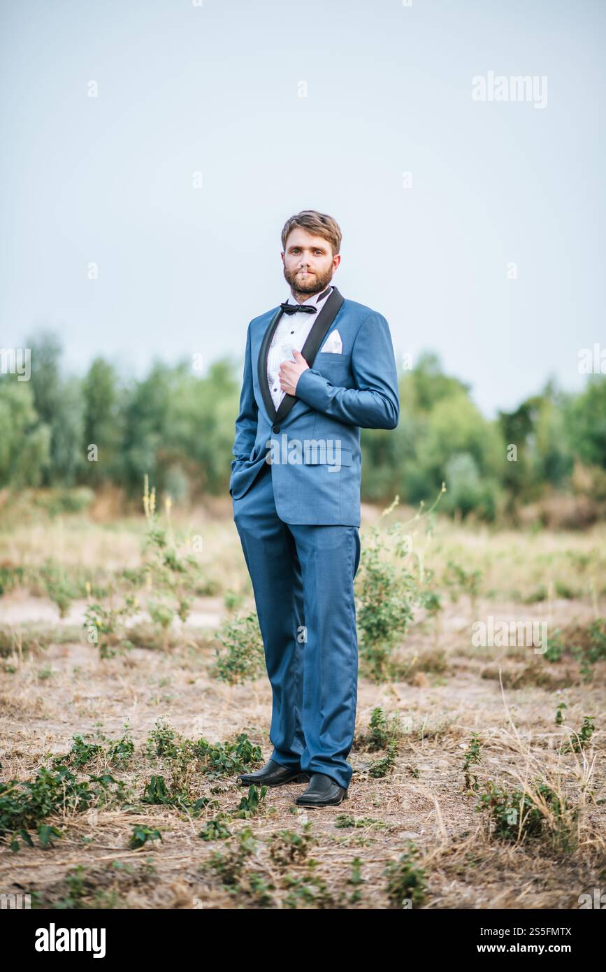 Beau marié en costume de mariage dans le parc Banque D'Images