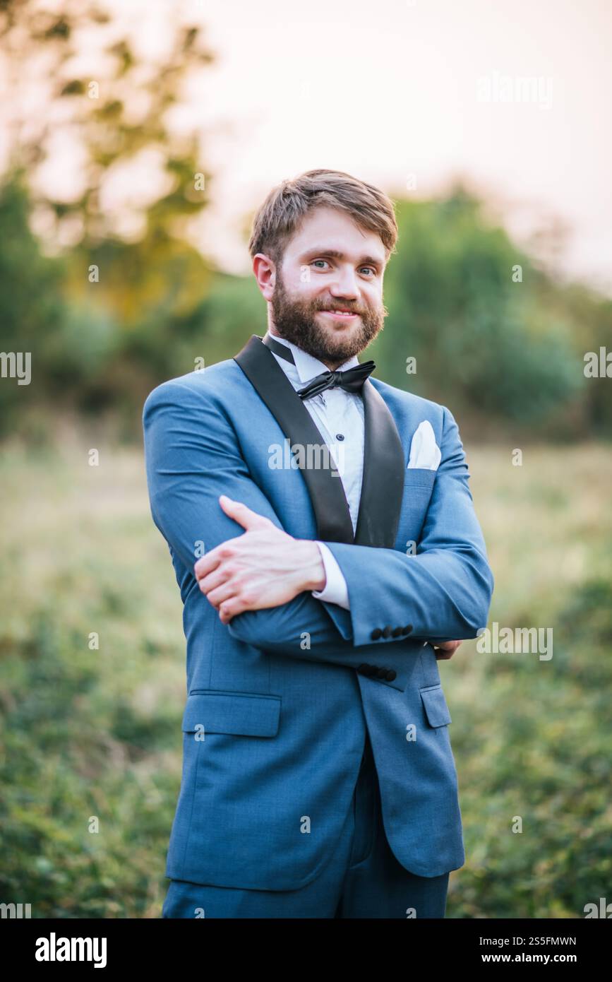 Beau marié en costume de mariage dans le parc Banque D'Images