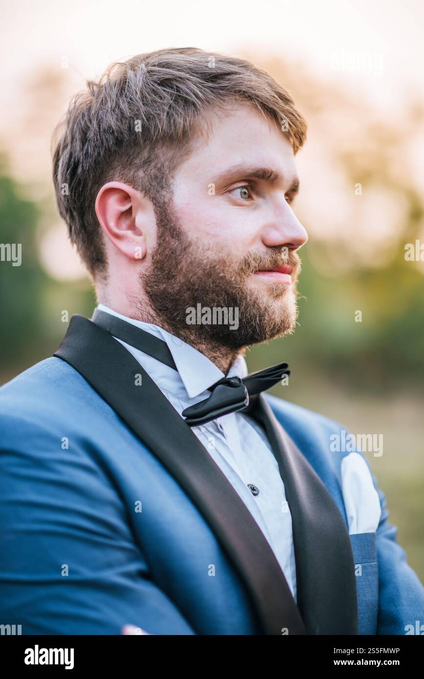 Beau marié en costume de mariage dans le parc Banque D'Images