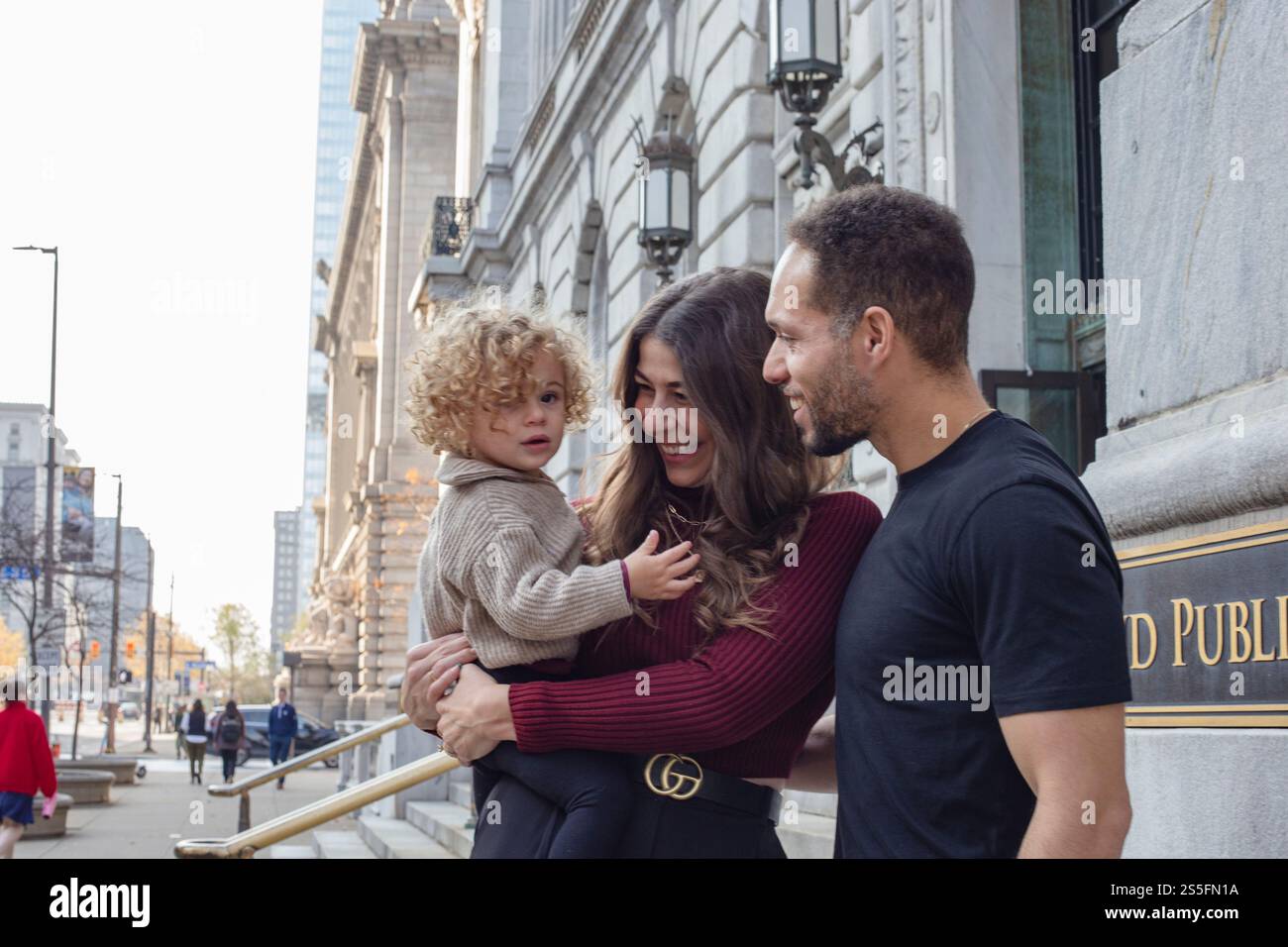 Famille de trois personnes profitant du temps ensemble à l'extérieur d'un bâtiment public Cleveland, public Library, Ohio, États-Unis Banque D'Images