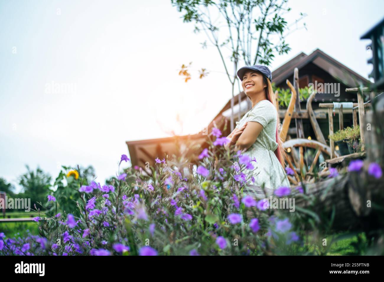 la femme est heureuse de se tenir dans le jardin fleuri dans les rampes en bois. Banque D'Images