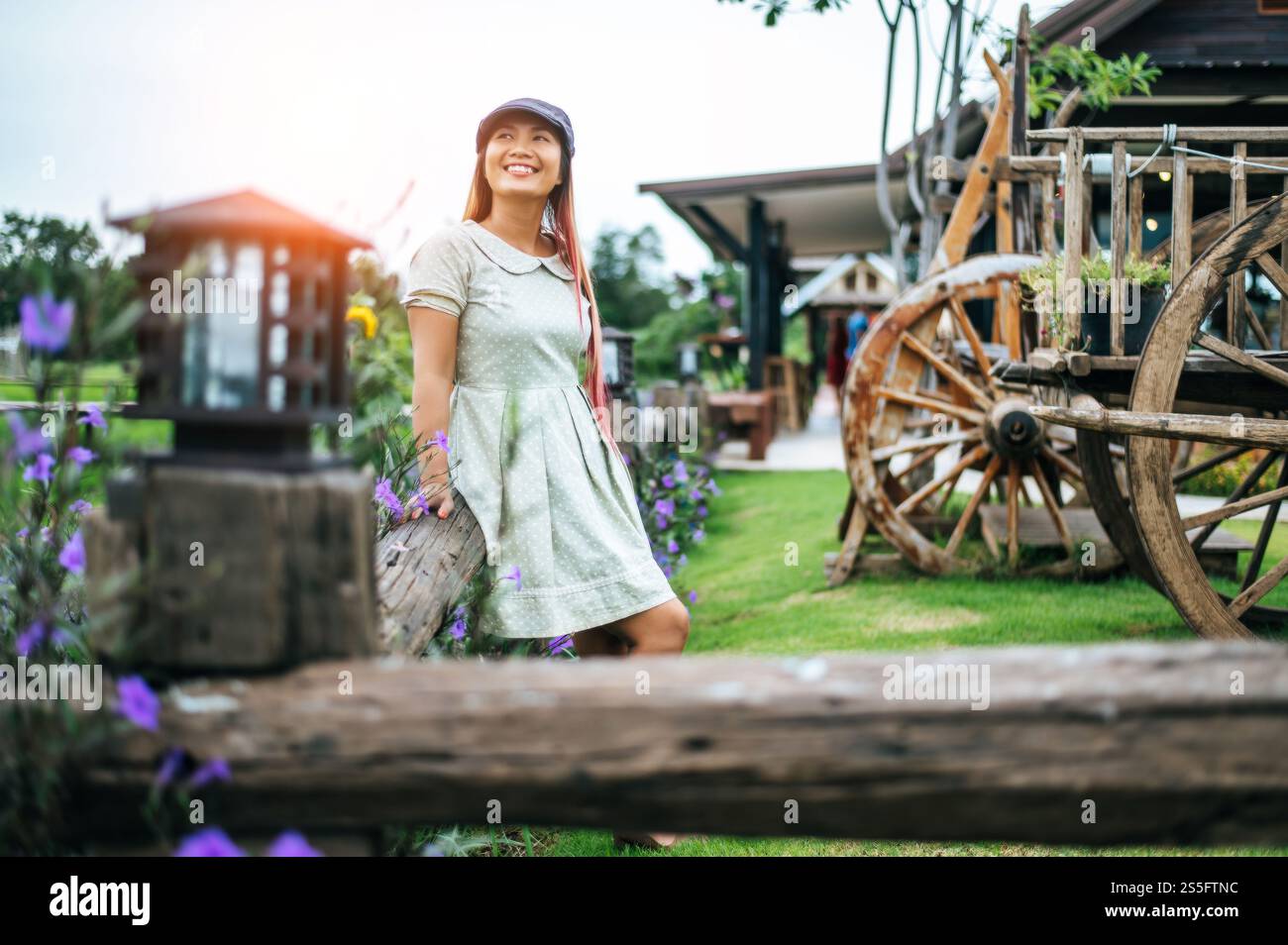 la femme est heureuse de se tenir dans le jardin fleuri dans les rampes en bois. Banque D'Images
