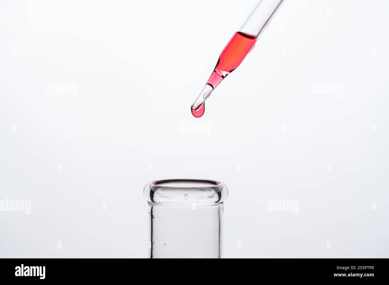 Déposez les produits chimiques rouges dans le bécher. Banque D'Images