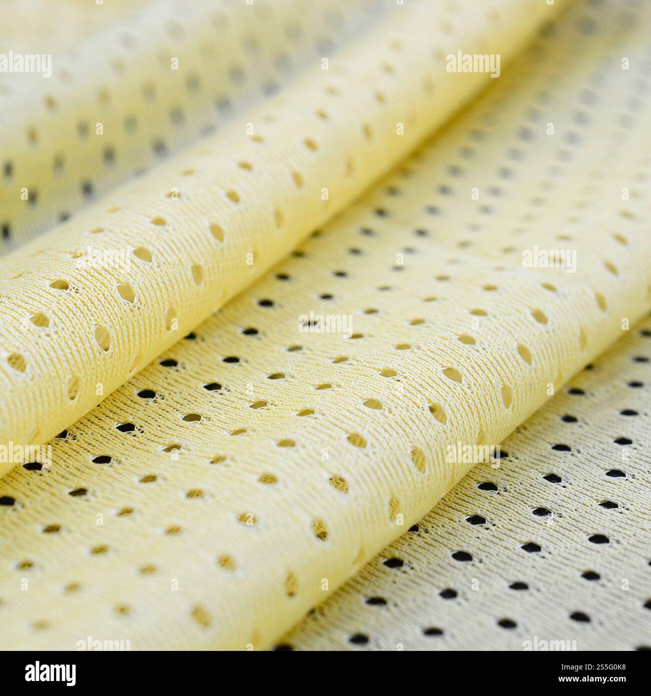 Fond de modèle textile de tissu de tissu de sport de maille jaune. Couleur jaune maillot de football vêtements tissu texture vêtements de sport. Poreux respirant Banque D'Images