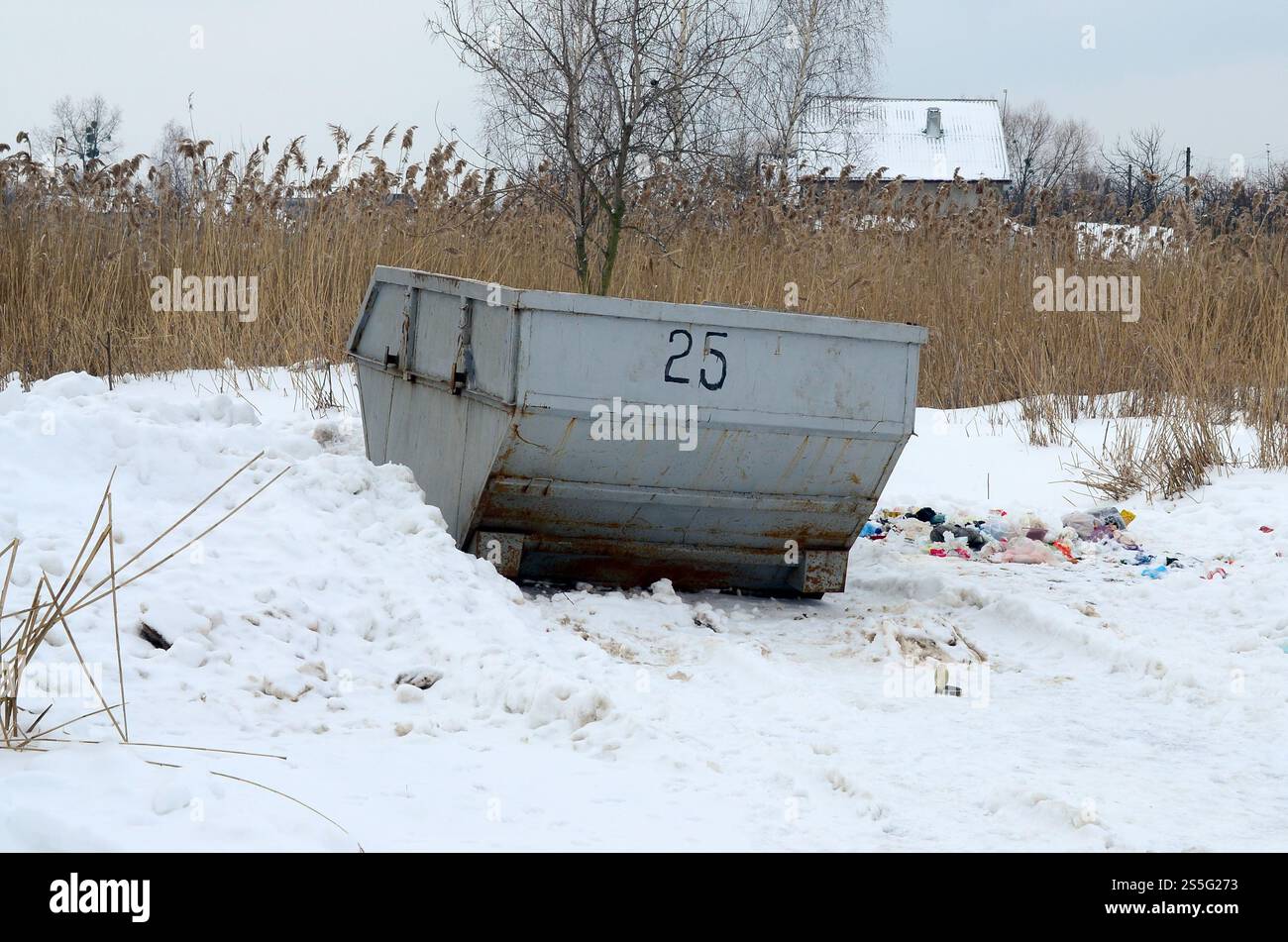 Poubelle sur le côté de la rue en hiver avec bac à déchets à lèvres hiver neige. Conteneur métallique pour déchets ménagers Banque D'Images