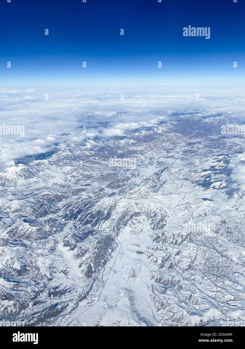 Vue aérienne des montagnes enneigées et des vallées du Caucase depuis un avion Banque D'Images