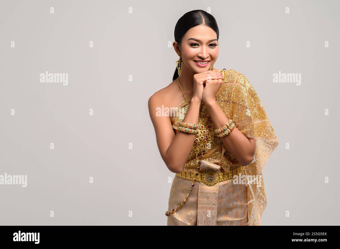 Les femmes portant des vêtements thaïlandais et les mains touchant le menton Banque D'Images