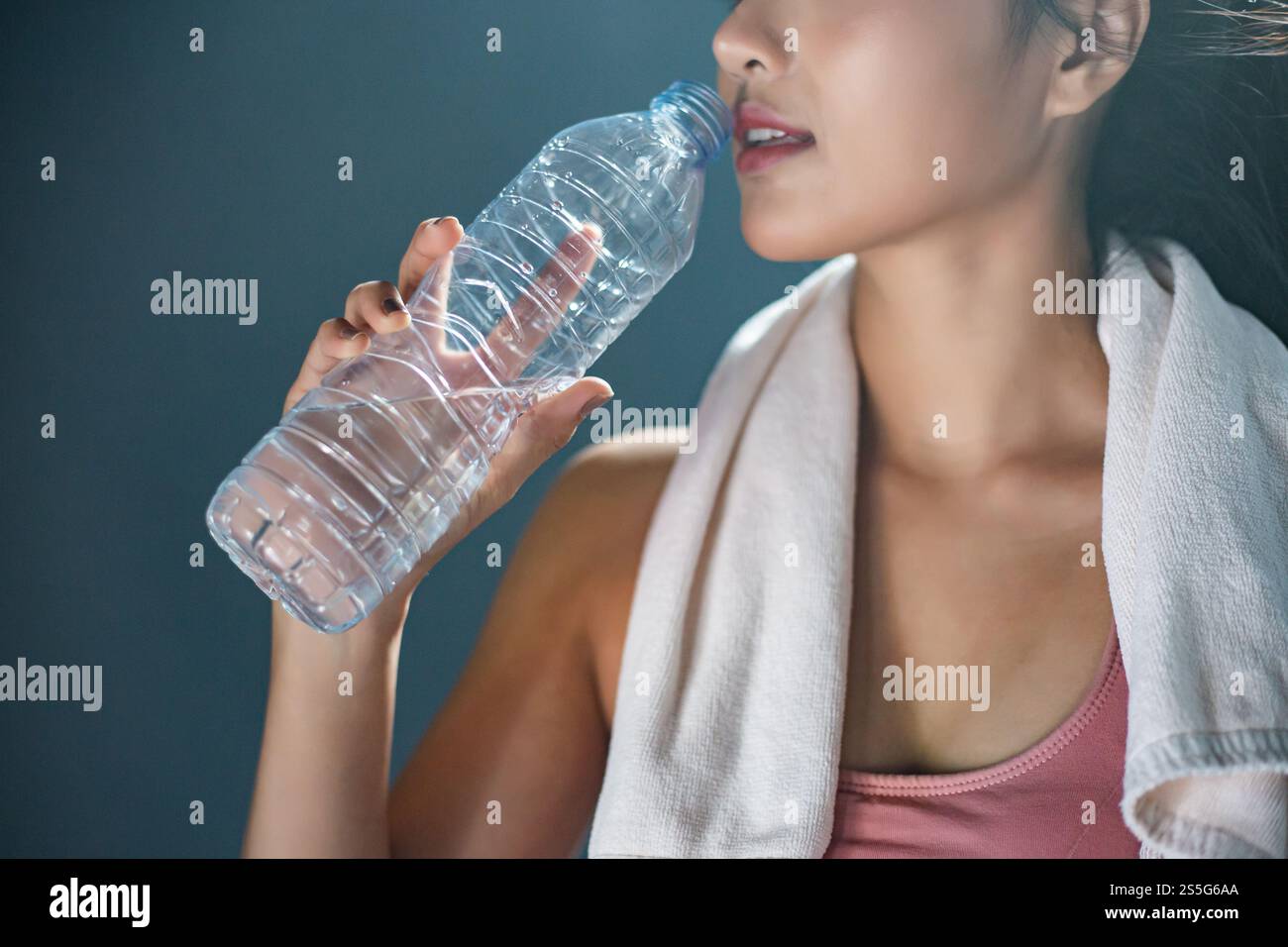 Après l'exercice, les femmes boivent de l'eau à partir de bouteilles et de mouchoirs dans la salle de gym. Banque D'Images