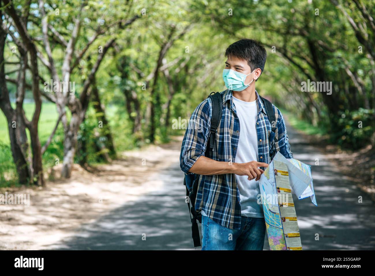 Les touristes masculins se tiennent debout et regardent la carte sur la route. Banque D'Images