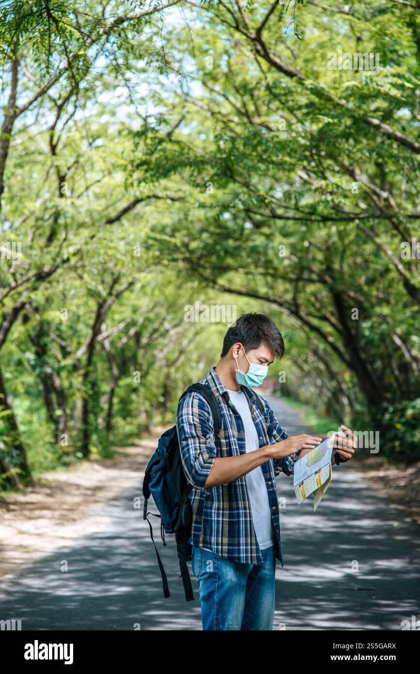 Les touristes masculins se tiennent debout et regardent la carte sur la route. Banque D'Images