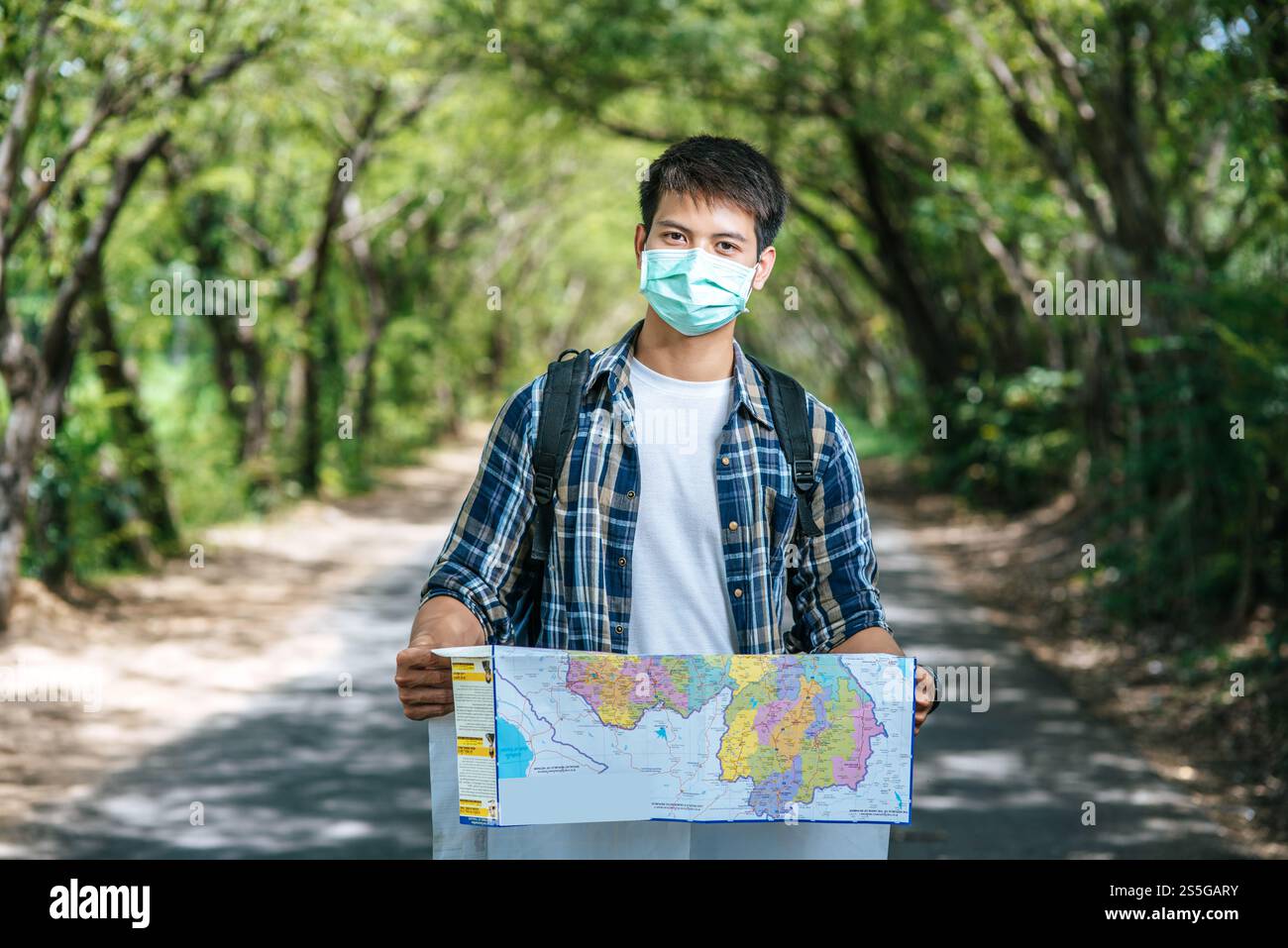 Les touristes masculins se tiennent debout et regardent la carte sur la route. Banque D'Images