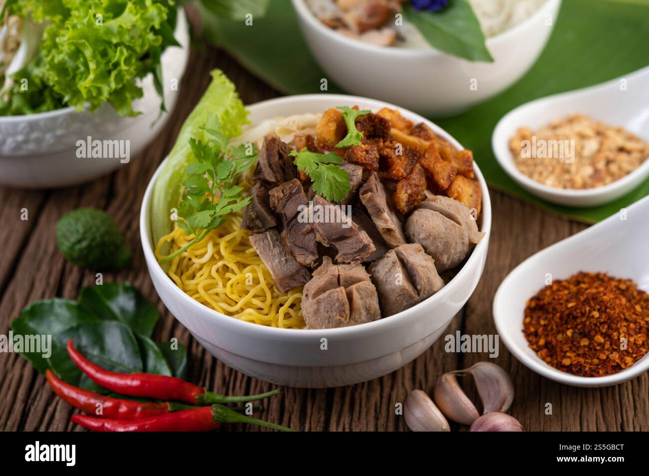 Nouilles jaunes dans une tasse avec du porc croustillant, des tranches de porc et des boulettes de viande avec des nouilles thaïlandaises Banque D'Images