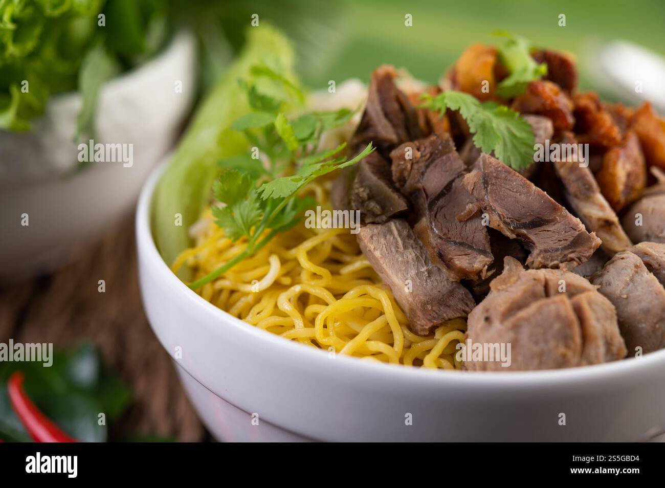Nouilles jaunes dans une tasse avec du porc croustillant, des tranches de porc et des boulettes de viande avec des nouilles thaïlandaises Banque D'Images