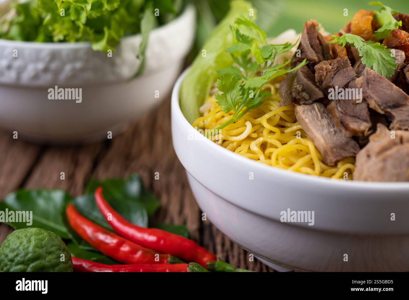 Nouilles jaunes dans une tasse avec du porc croustillant, des tranches de porc et des boulettes de viande avec des nouilles thaïlandaises Banque D'Images
