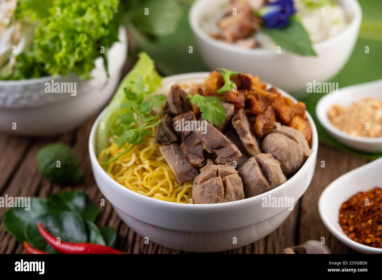 Nouilles jaunes dans une tasse avec du porc croustillant, des tranches de porc et des boulettes de viande avec des nouilles thaïlandaises Banque D'Images