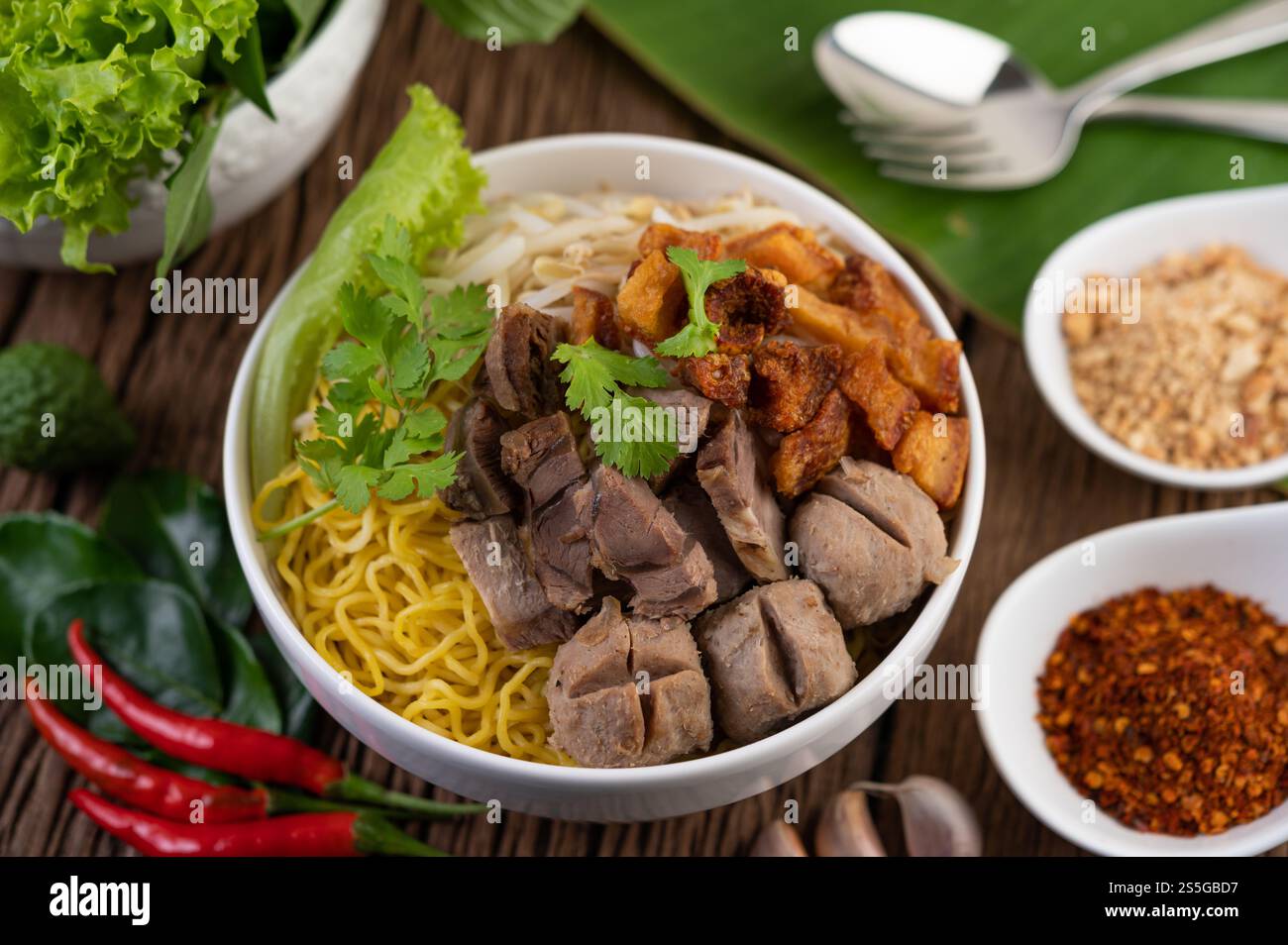 Nouilles jaunes dans une tasse avec du porc croustillant, des tranches de porc et des boulettes de viande avec des nouilles thaïlandaises Banque D'Images