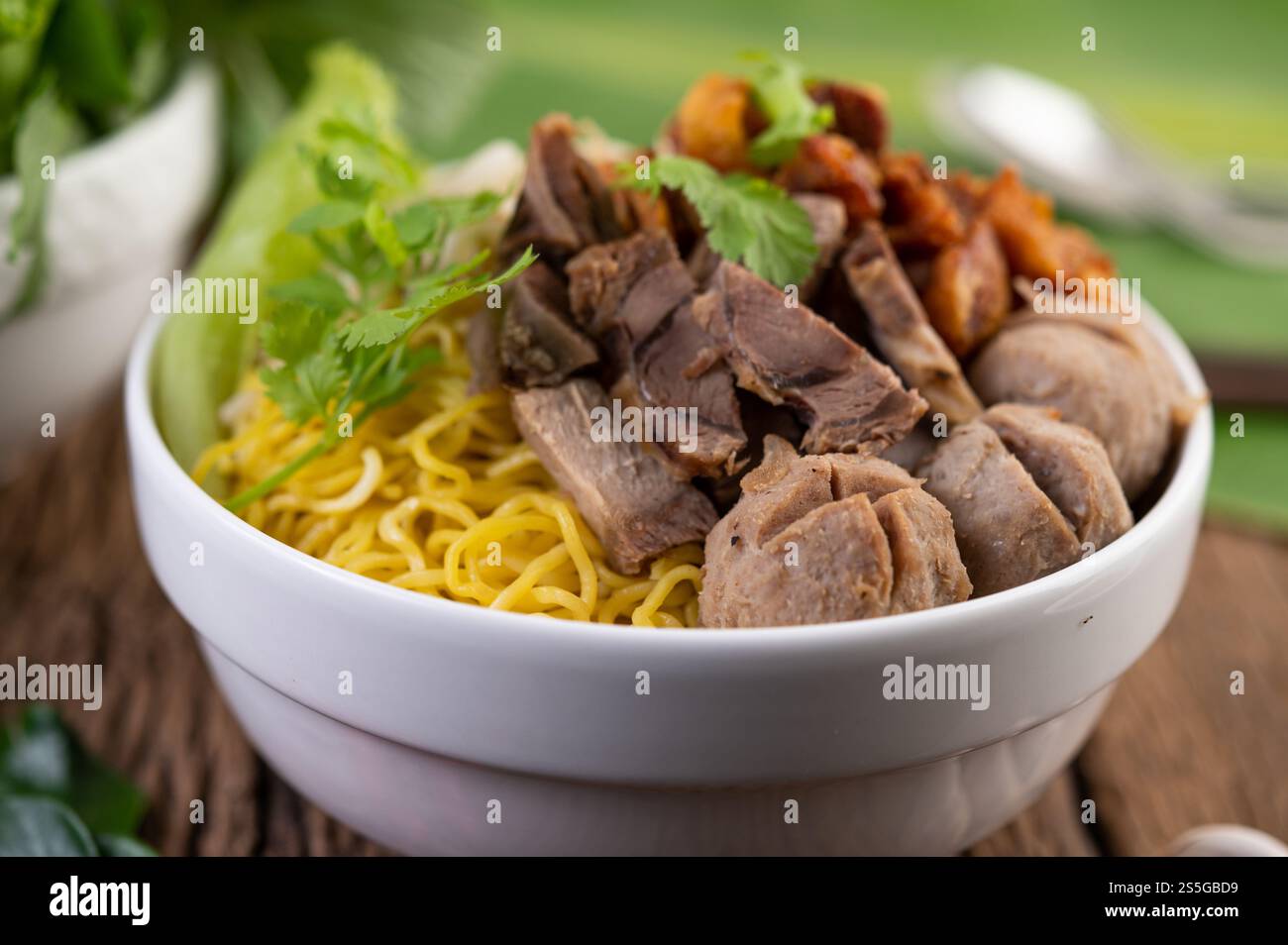 Nouilles jaunes dans une tasse avec du porc croustillant, des tranches de porc et des boulettes de viande avec des nouilles thaïlandaises Banque D'Images