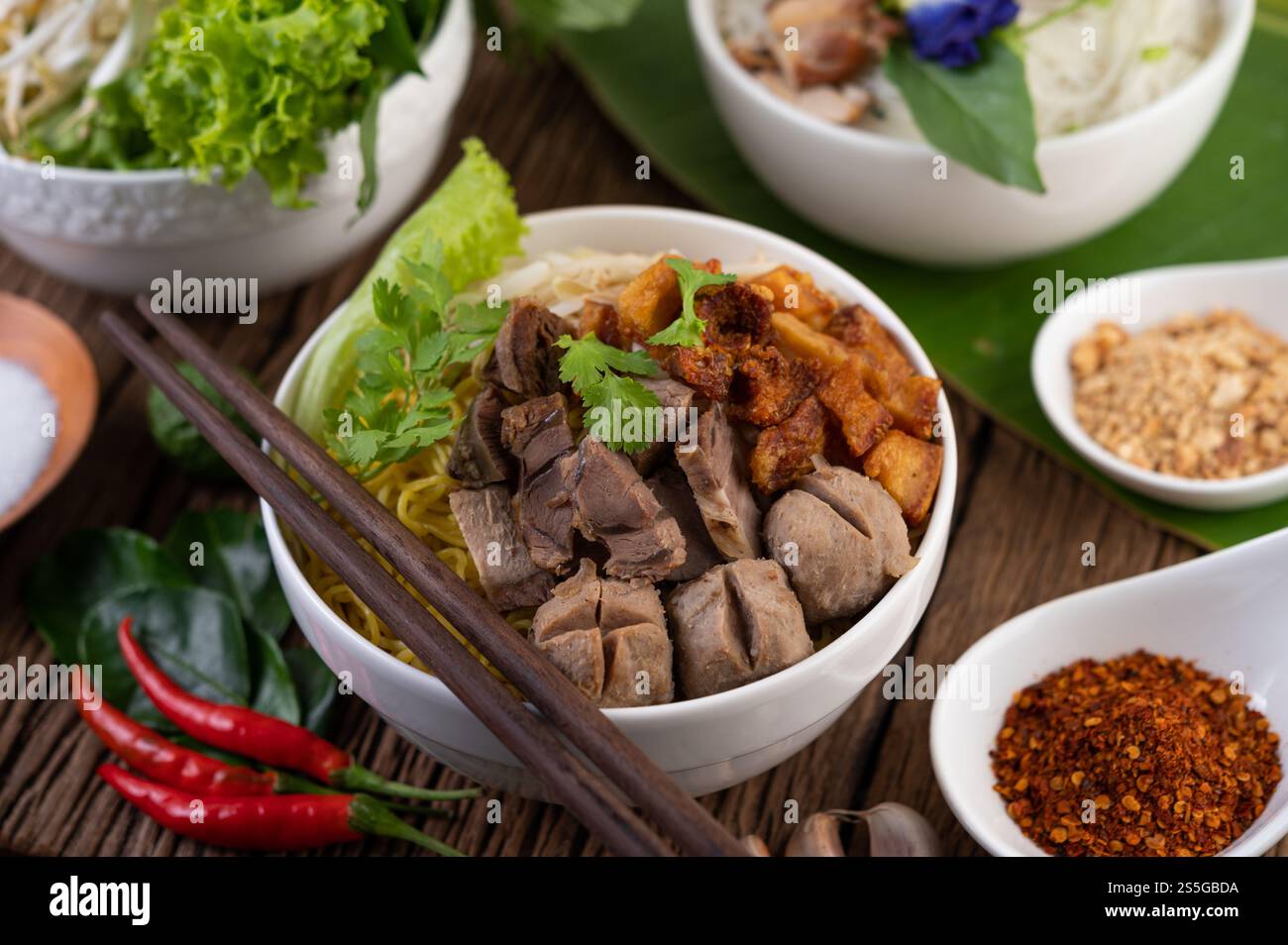 Nouilles jaunes dans une tasse avec du porc croustillant, des tranches de porc et des boulettes de viande avec des nouilles thaïlandaises Banque D'Images