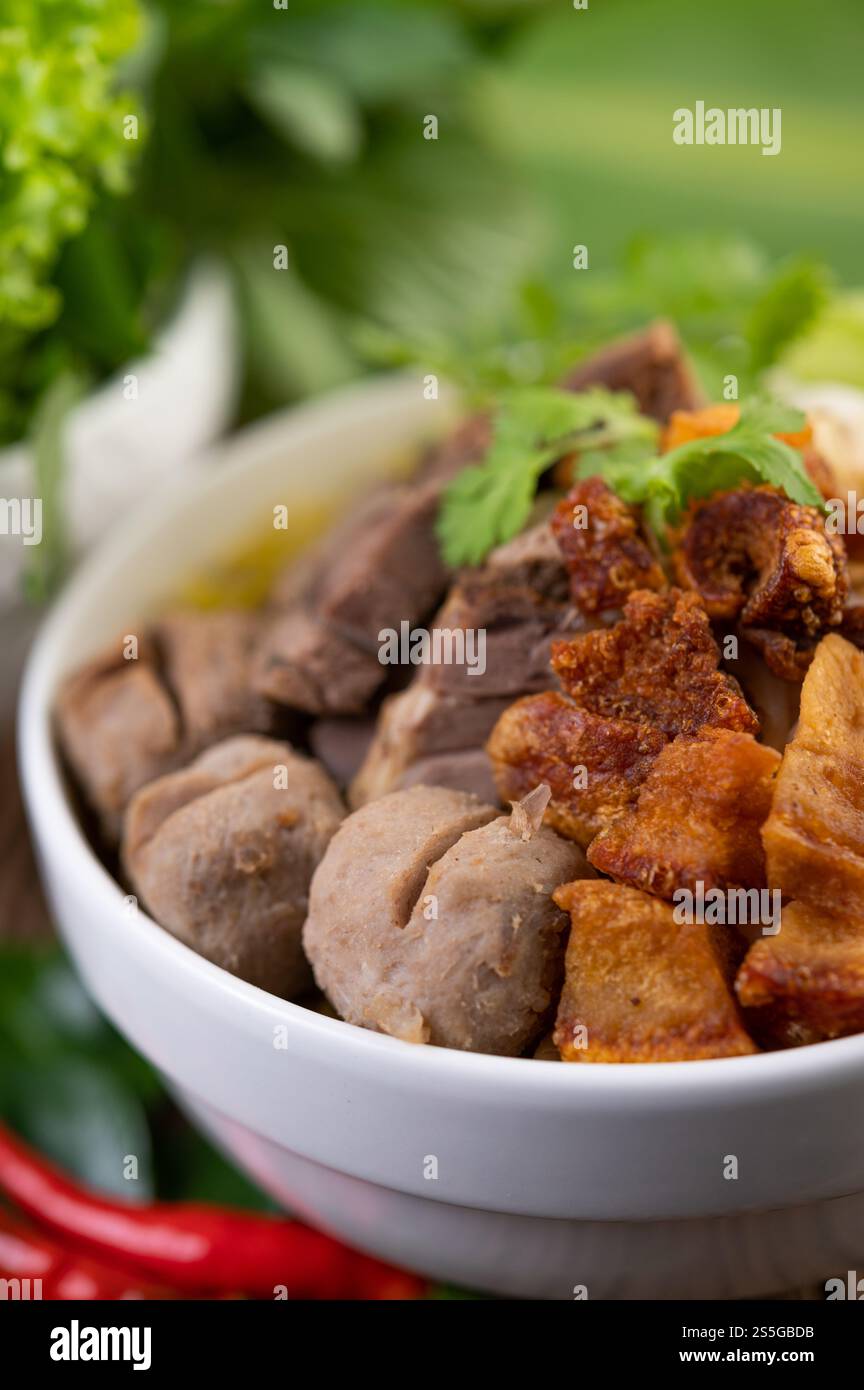 Nouilles jaunes dans une tasse avec du porc croustillant, des tranches de porc et des boulettes de viande avec des nouilles thaïlandaises Banque D'Images