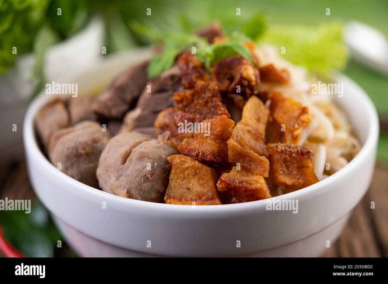Nouilles jaunes dans une tasse avec du porc croustillant, des tranches de porc et des boulettes de viande avec des nouilles thaïlandaises Banque D'Images