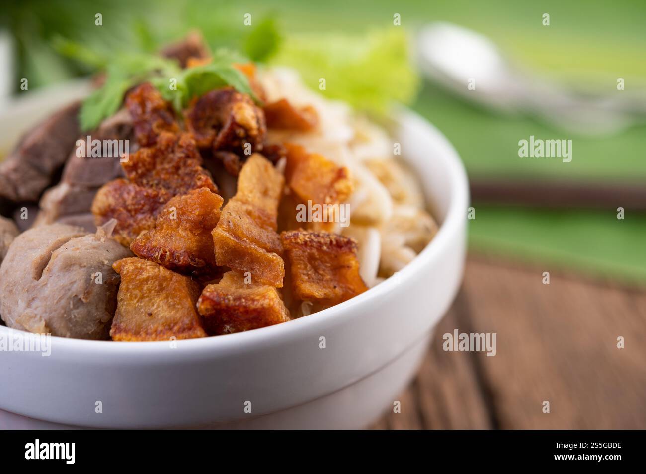 Nouilles jaunes dans une tasse avec du porc croustillant, des tranches de porc et des boulettes de viande avec des nouilles thaïlandaises Banque D'Images