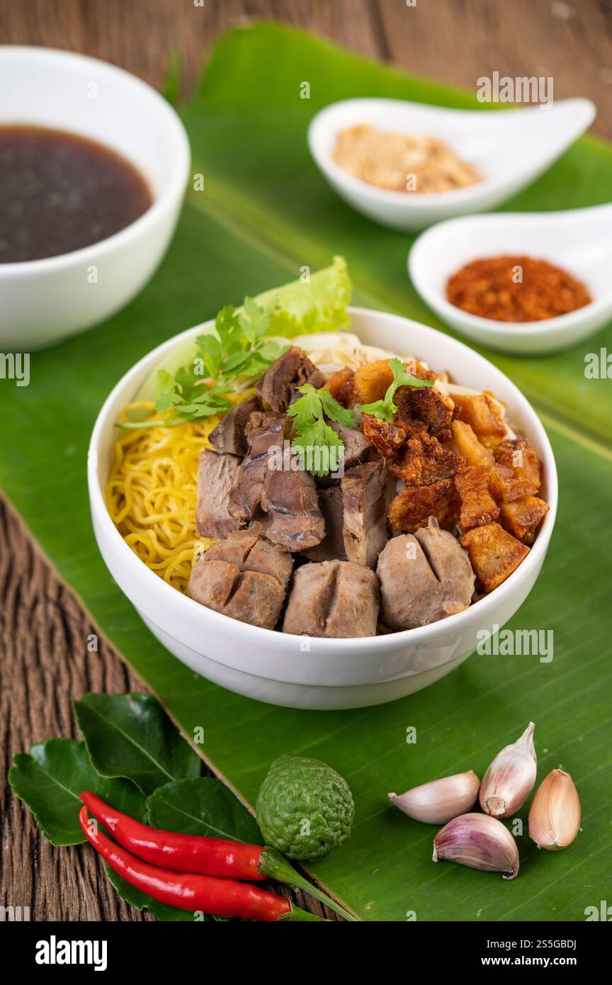 Nouilles jaunes dans une tasse avec du porc croustillant, des tranches de porc et des boulettes de viande avec des nouilles thaïlandaises Banque D'Images